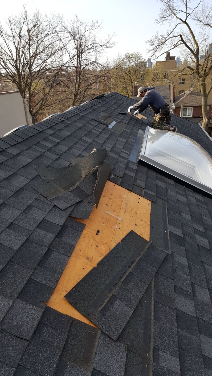 Roofer repairing storm-damaged shingles